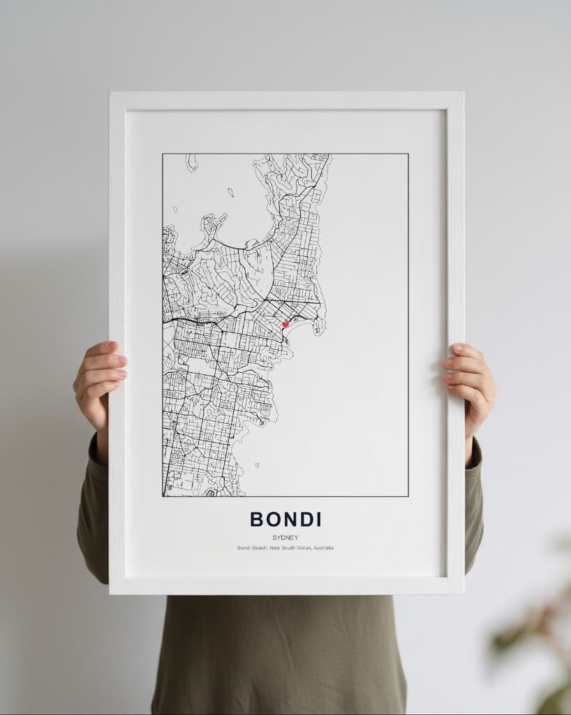 Framed Bondi Sydney map print in a white frame with mat; minimal typography and heart marker on the map.